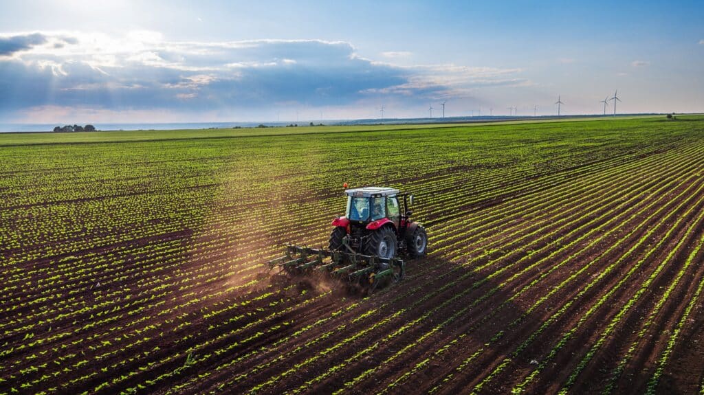 Traktor auf einem weitläufigen Feld bei präziser Arbeit