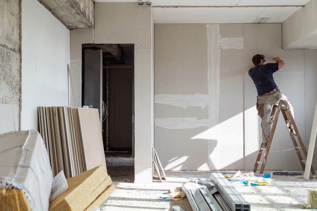 Handwerker montiert Wandpaneele – Umgebung erfordert anschliessend gruendliche baustellenreinigung